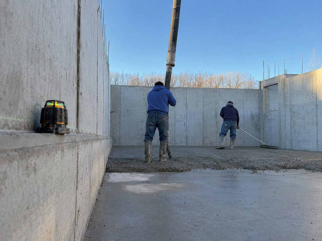 Gomez Concrete crew screeding a basement floor slab inside new foundation walls in Sioux Falls, SD