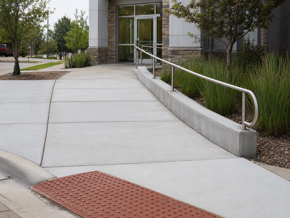 Commercial entrance walk with ADA ramp, railing and detectable warning panel by Gomez Concrete LLC in Sioux Falls, SD
