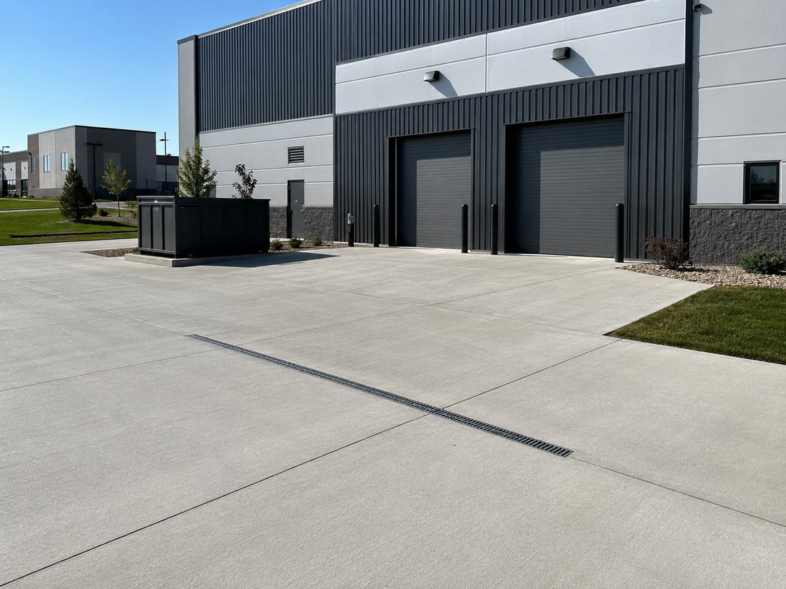 Commercial loading apron with flush trench drain and clean joint layout at a Sioux Falls, SD building